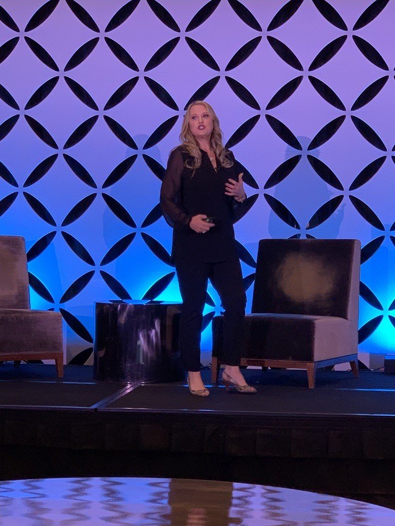 Elizabeth Edwards speaking on a blue-lit stage in Nashville