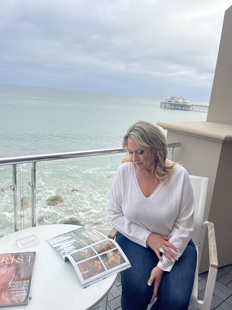 Elizabeth Edwards reading beside the ocean in Malibu